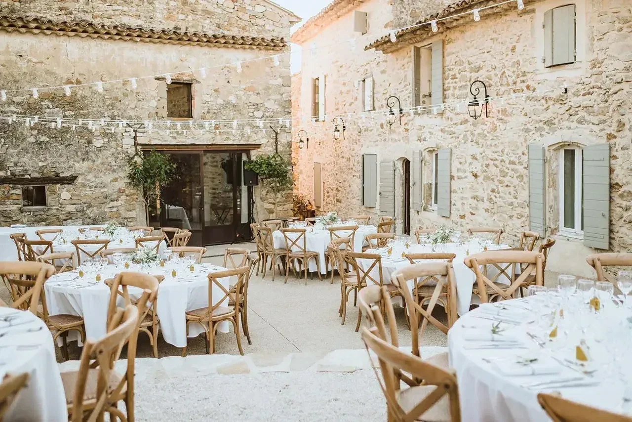 Dîner de mariage dans une cour en pierre Tables du dîner de mariage dressées dans une cour en pierre