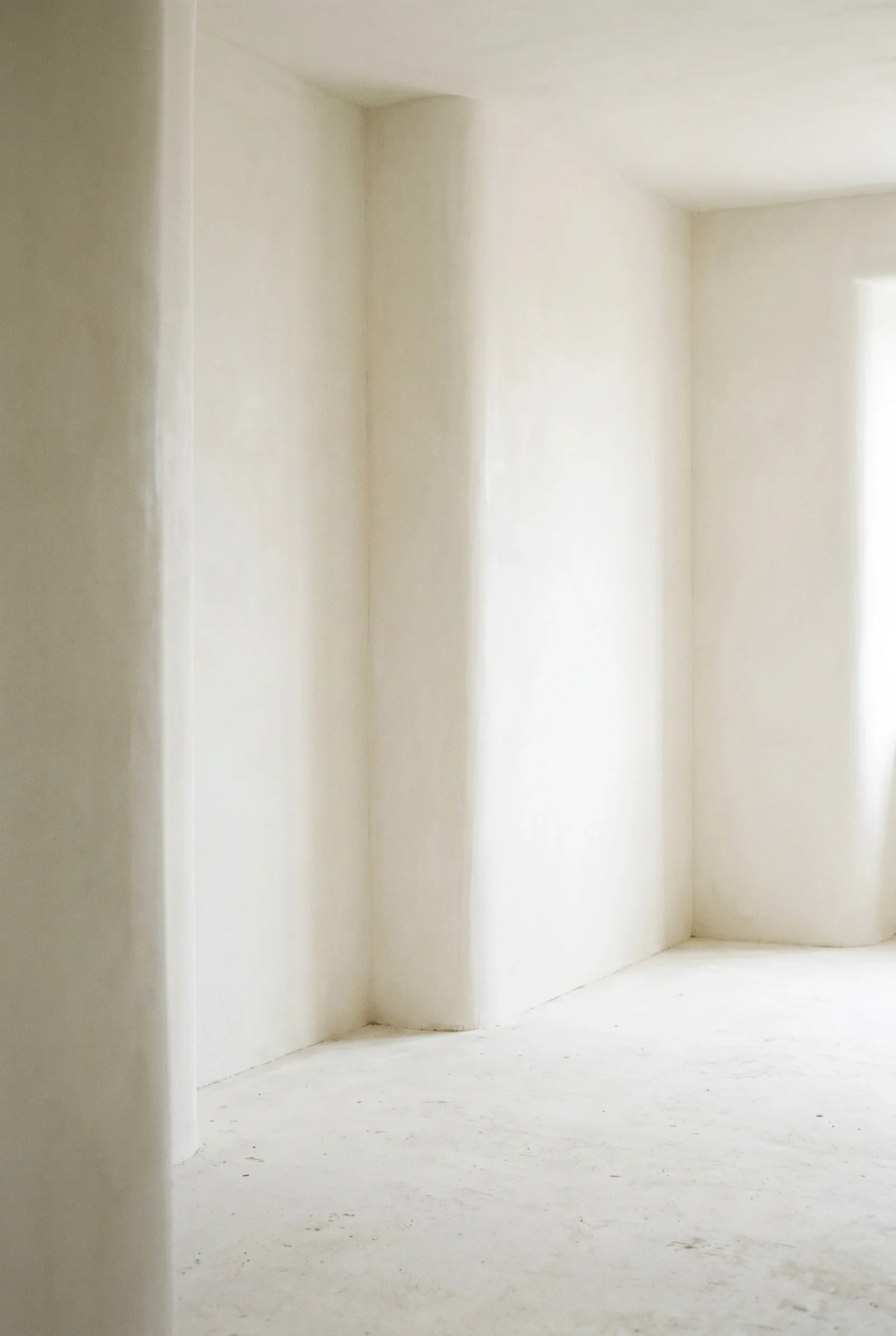 Pièce aux murs blancs arrondis, décor des photos de la collection La Septième