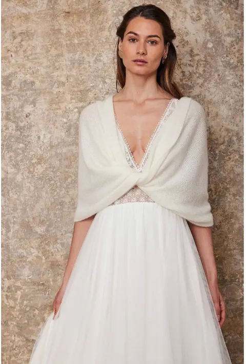 Étole snood en laine mohair ivoire croisée sur le buste, portée sur une robe de mariée à décolleté en V