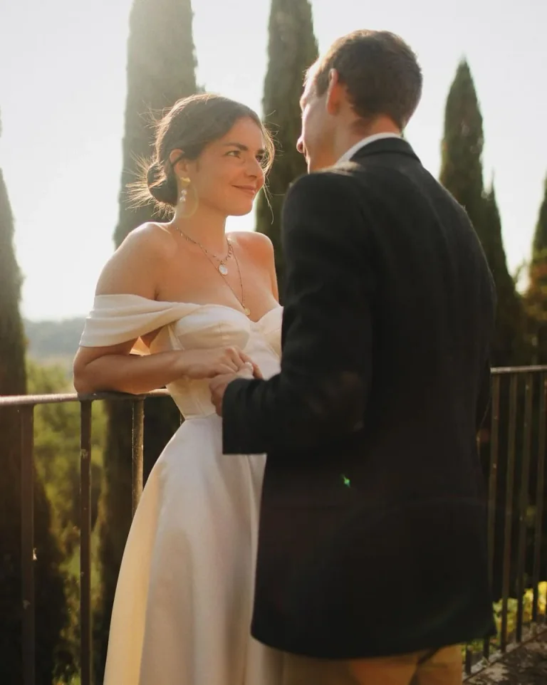 Mariée en robe sur mesure en satin de soie face au marié, cyprès de Toscane