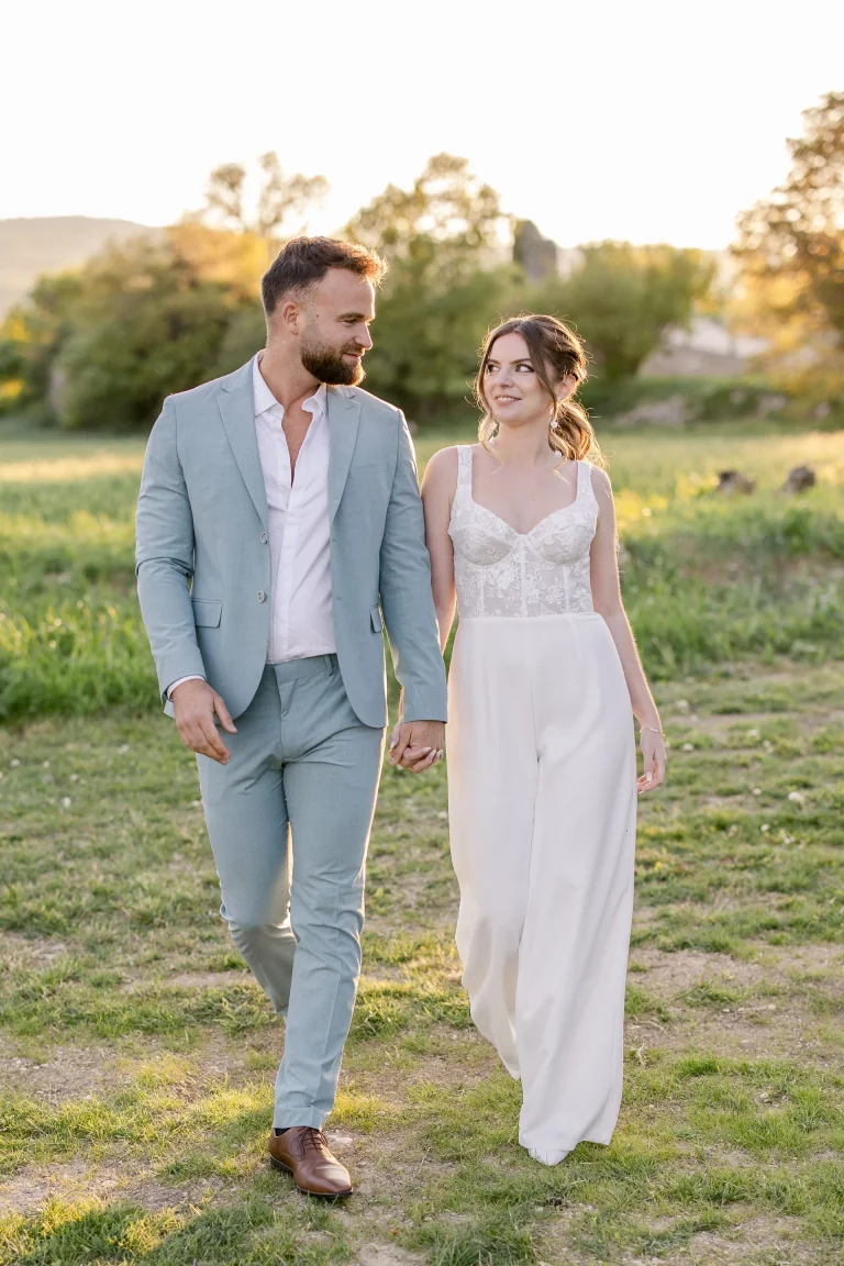 Mariée en combinaison Lolette à bustier brodé marchant avec le marié