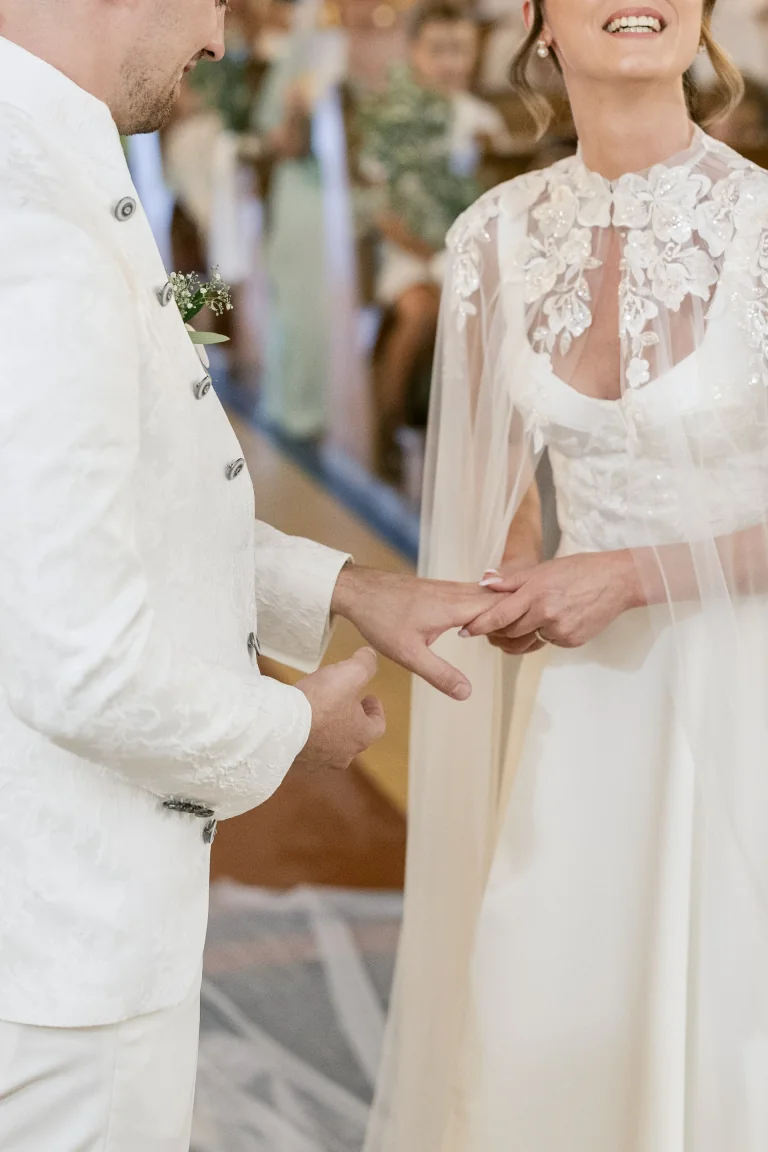 Échange des alliances, mariée en cape de dentelle brodée