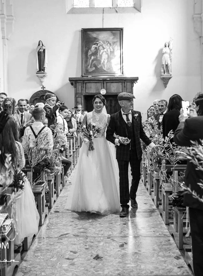 Entrée de la mariée à l'église au bras de son père, en noir et blanc