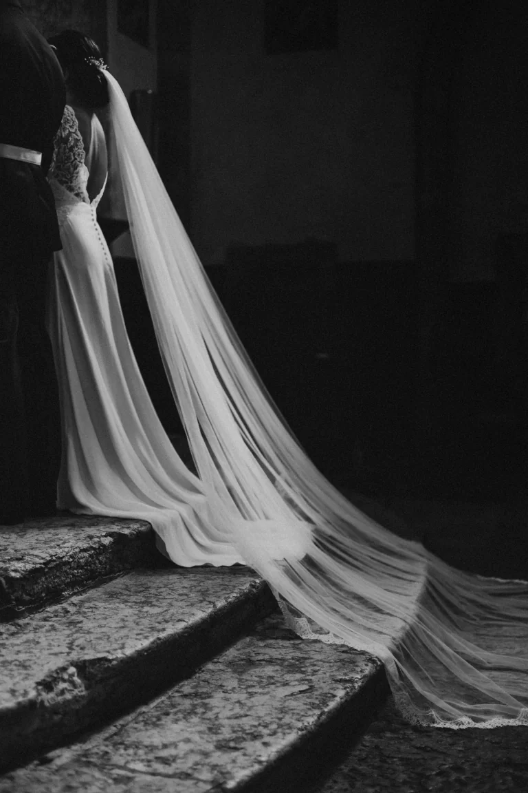 Long voile de tulle déployé sur des marches en pierre, en noir et blanc