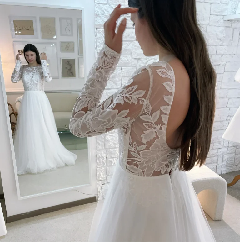Essayage d'une robe à manches longues en dentelle et jupe en tulle au showroom