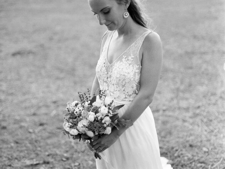 Mariée tenant son bouquet, robe à bretelles en dentelle, en noir et blanc