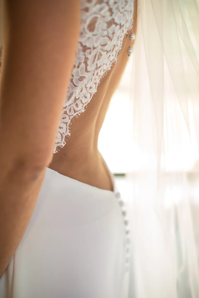 Détail d'un dos en dentelle et boutons recouverts en contre-jour