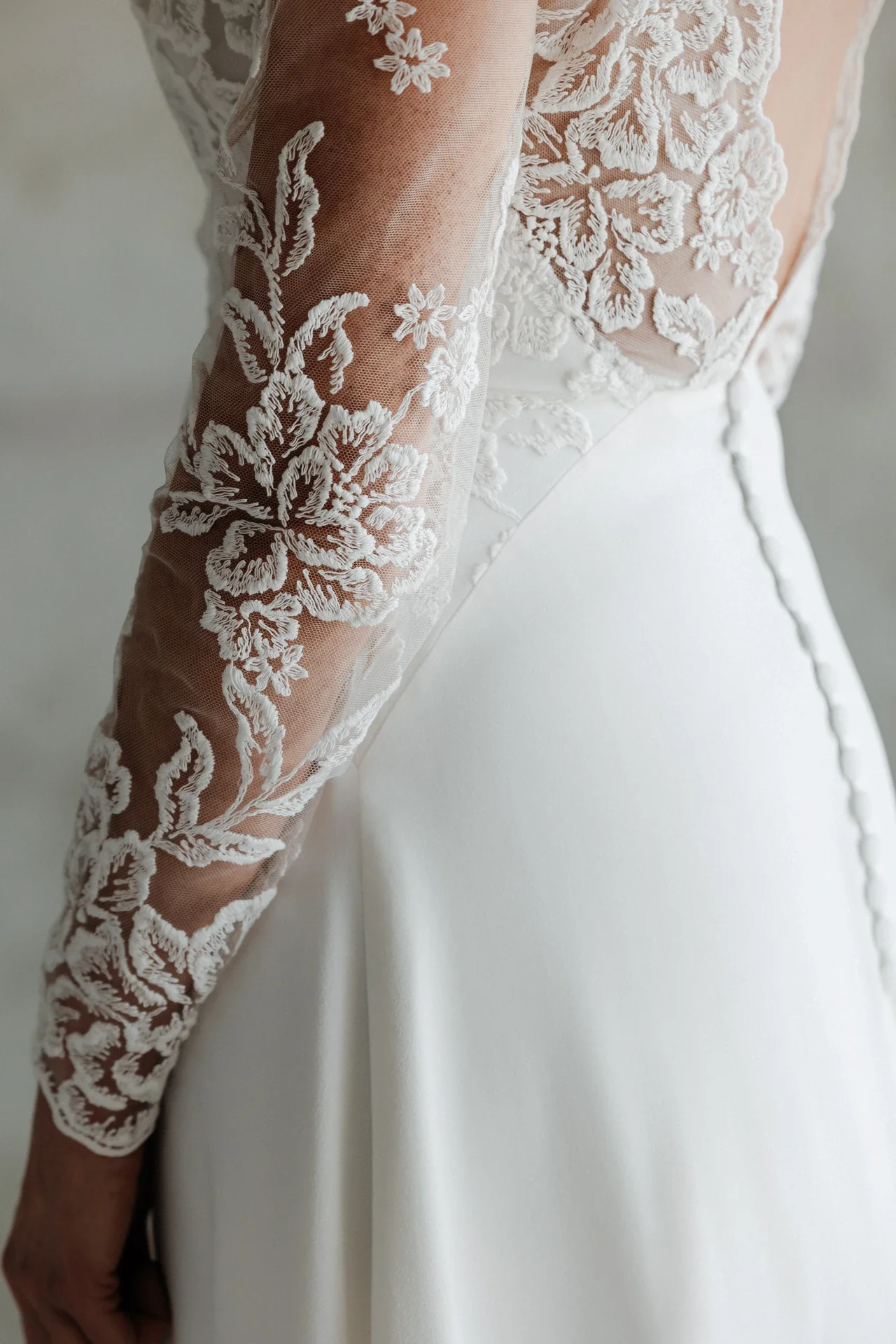 Manche longue en dentelle brodée et dos boutonné de la robe Jennah