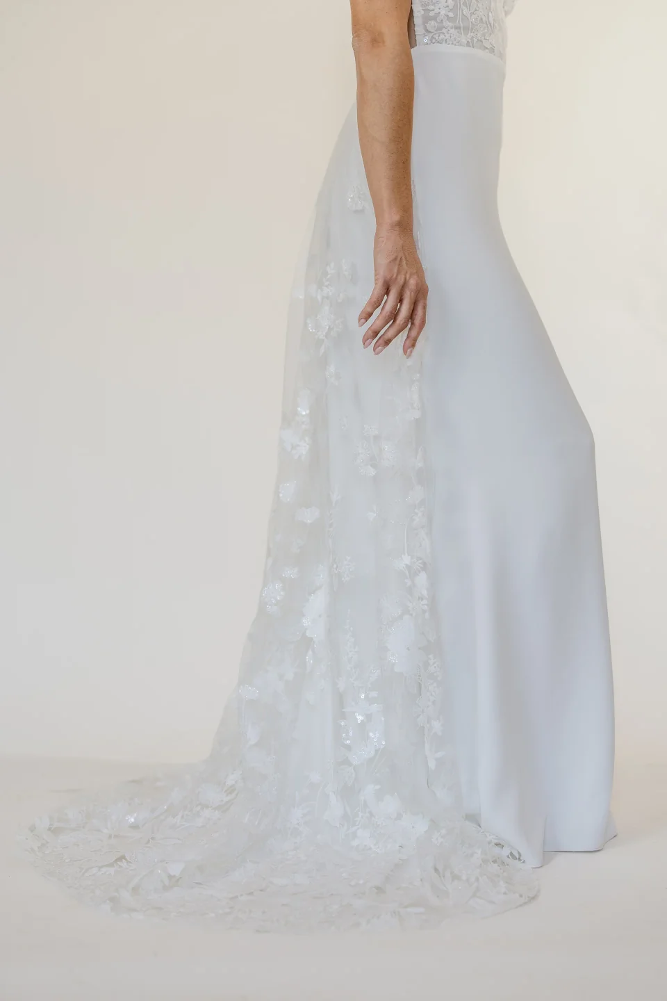 Robe Mona vue de dos, traîne en dentelle tenue à la main