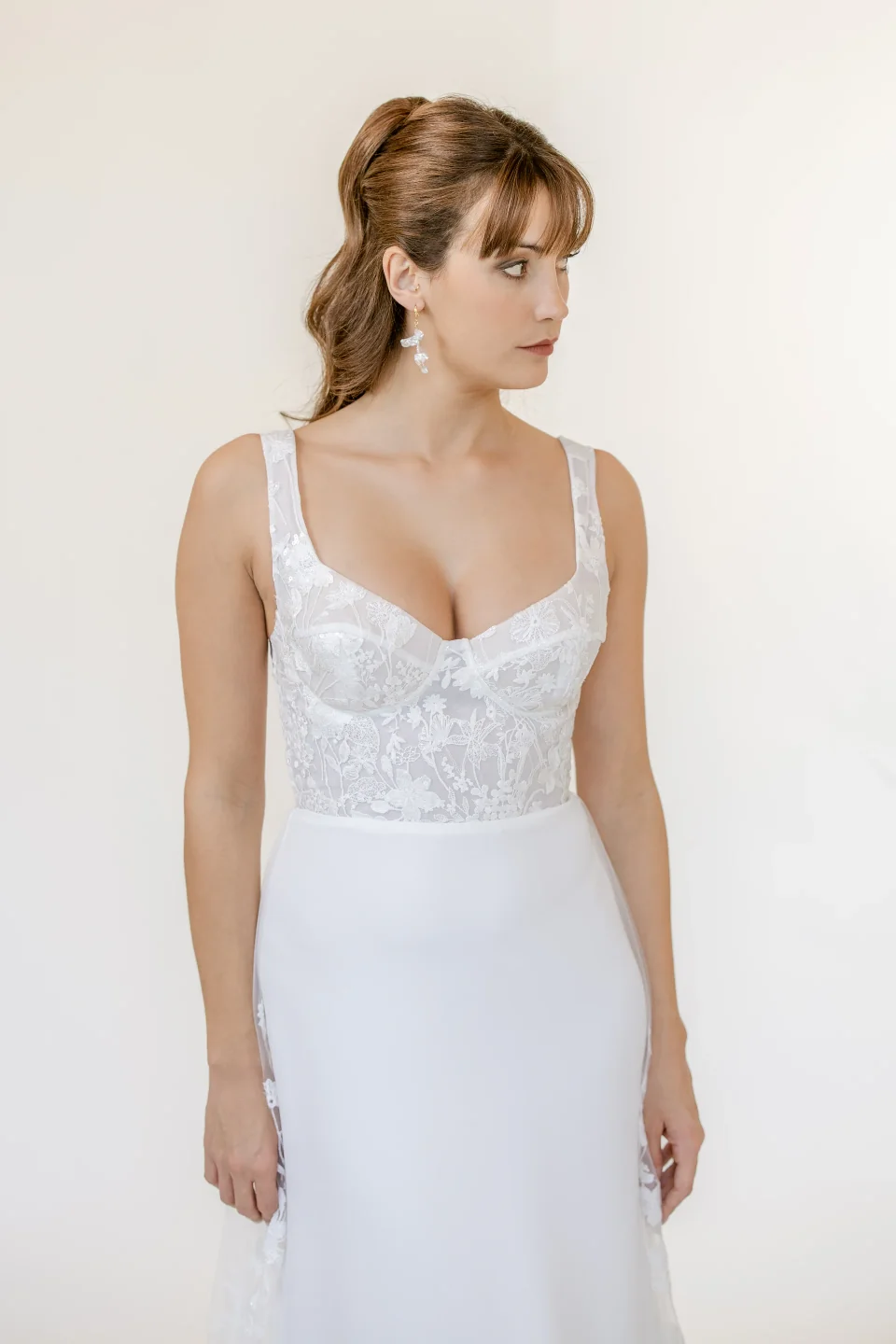 Robe Mona entre deux panneaux blancs, bras levé