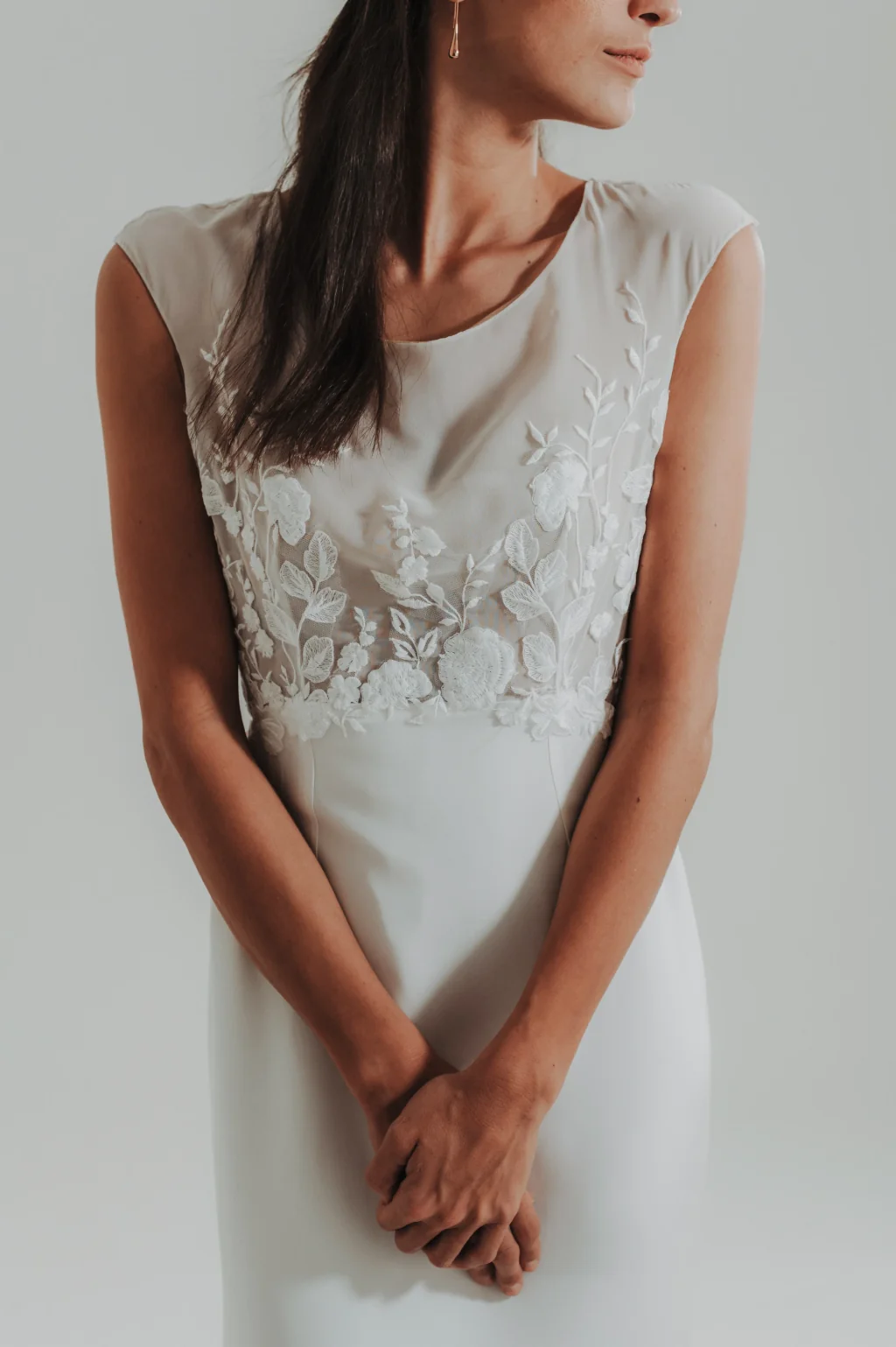 Robe de mariée Cooper en promotion, détail du buste en dentelle sur tulle, mains jointes