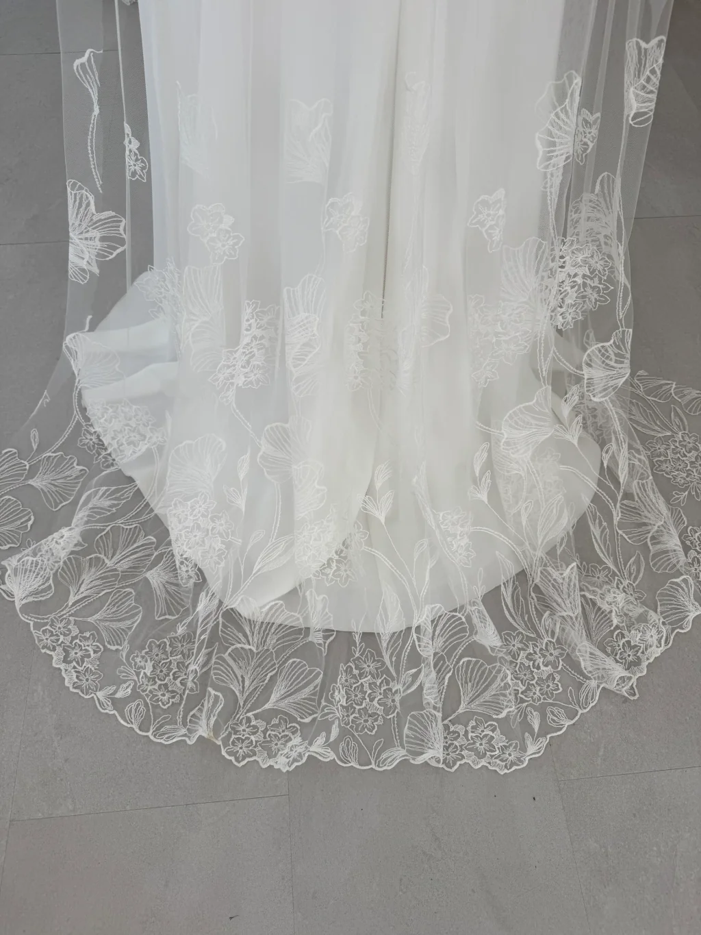 Robe de mariée Leane en promotion, détail de la traîne bordée de dentelle