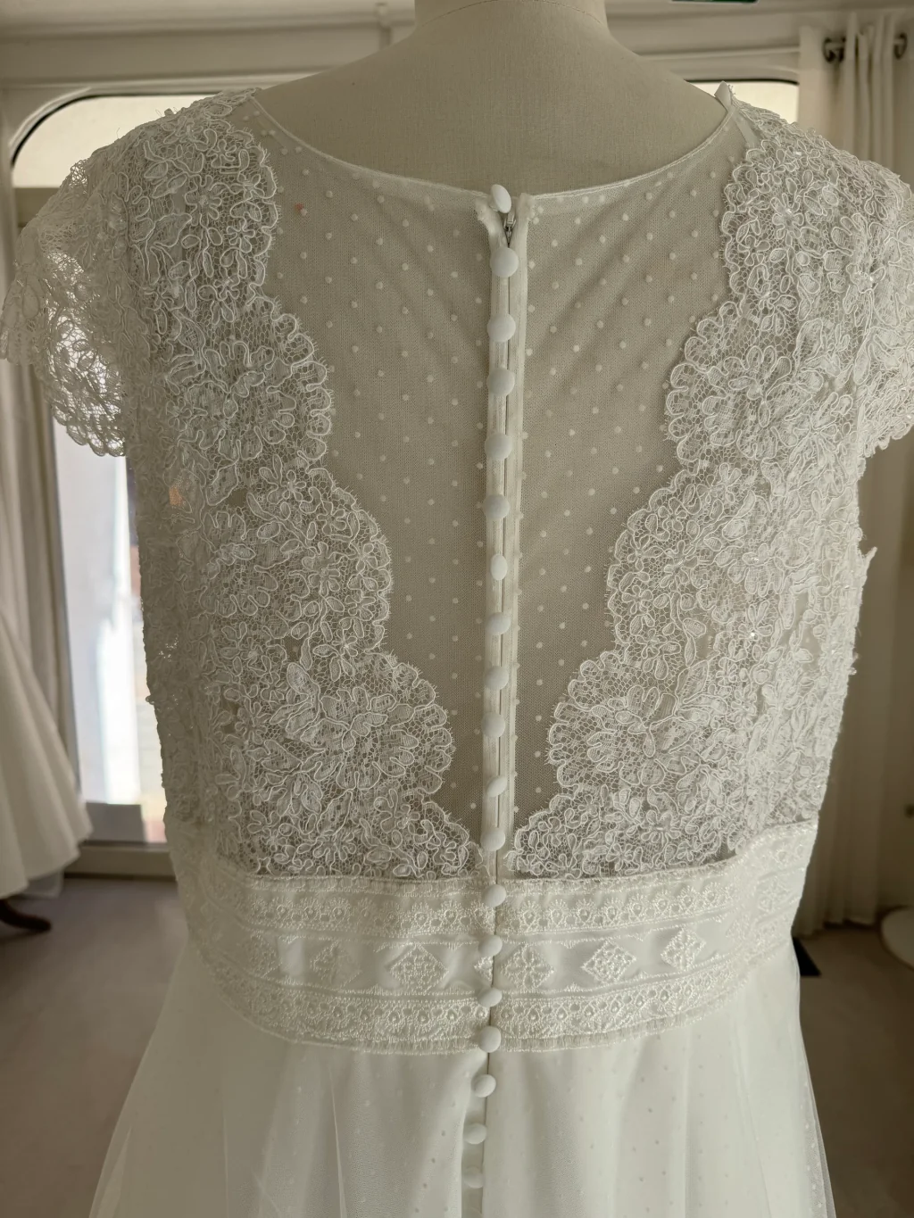 Robe de mariée Manosque en promotion, dos en dentelle sur mannequin, rangée de boutons