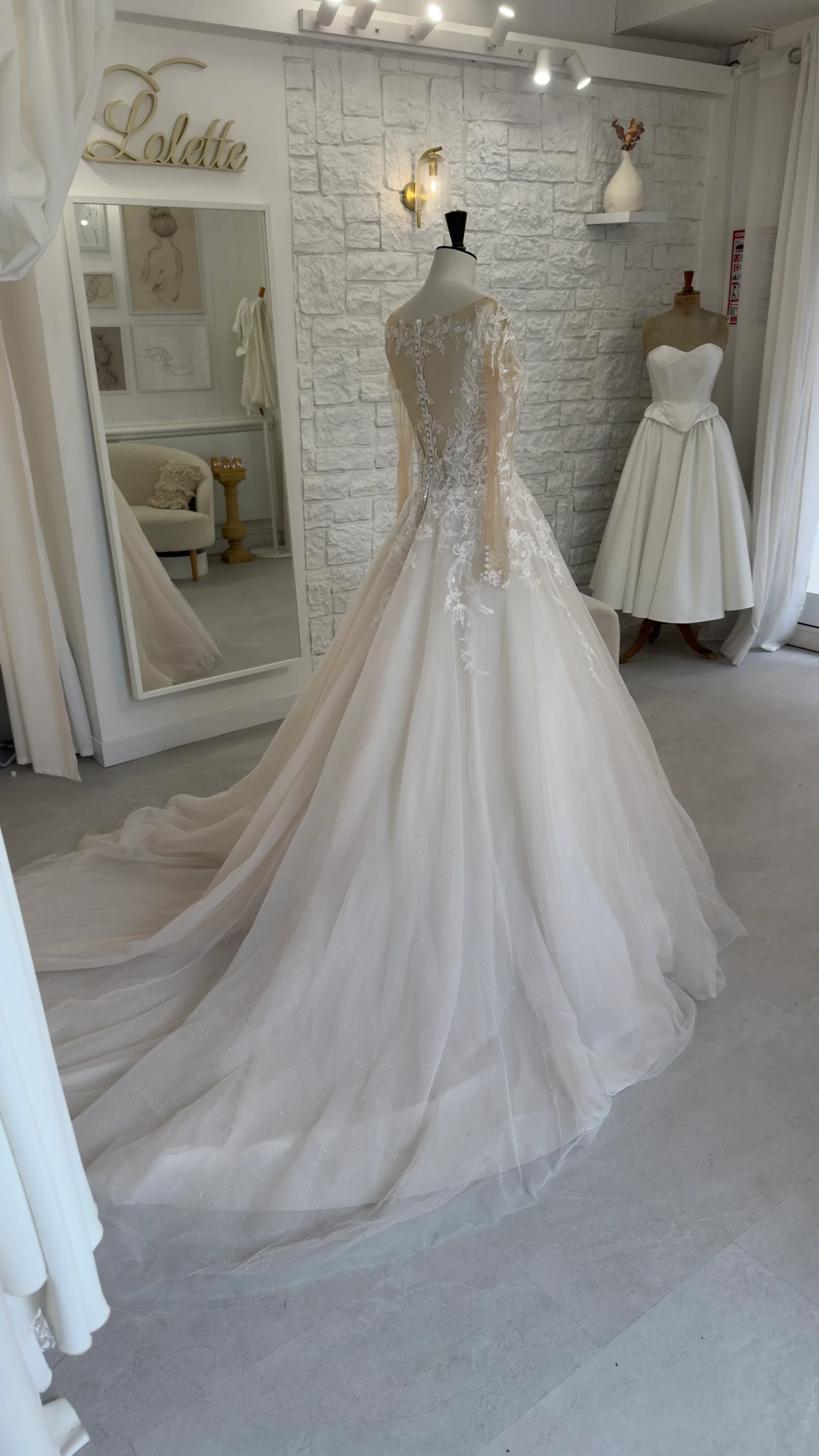 Robe de mariée Marlene en promotion, de profil au showroom, longue traîne