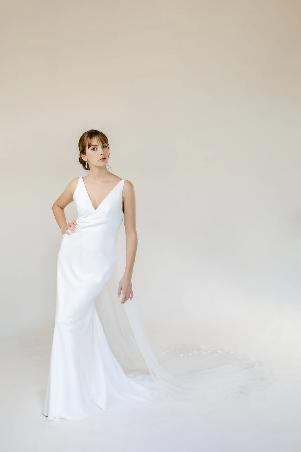 Robe fluide à décolleté en V portée sous la cape Saul