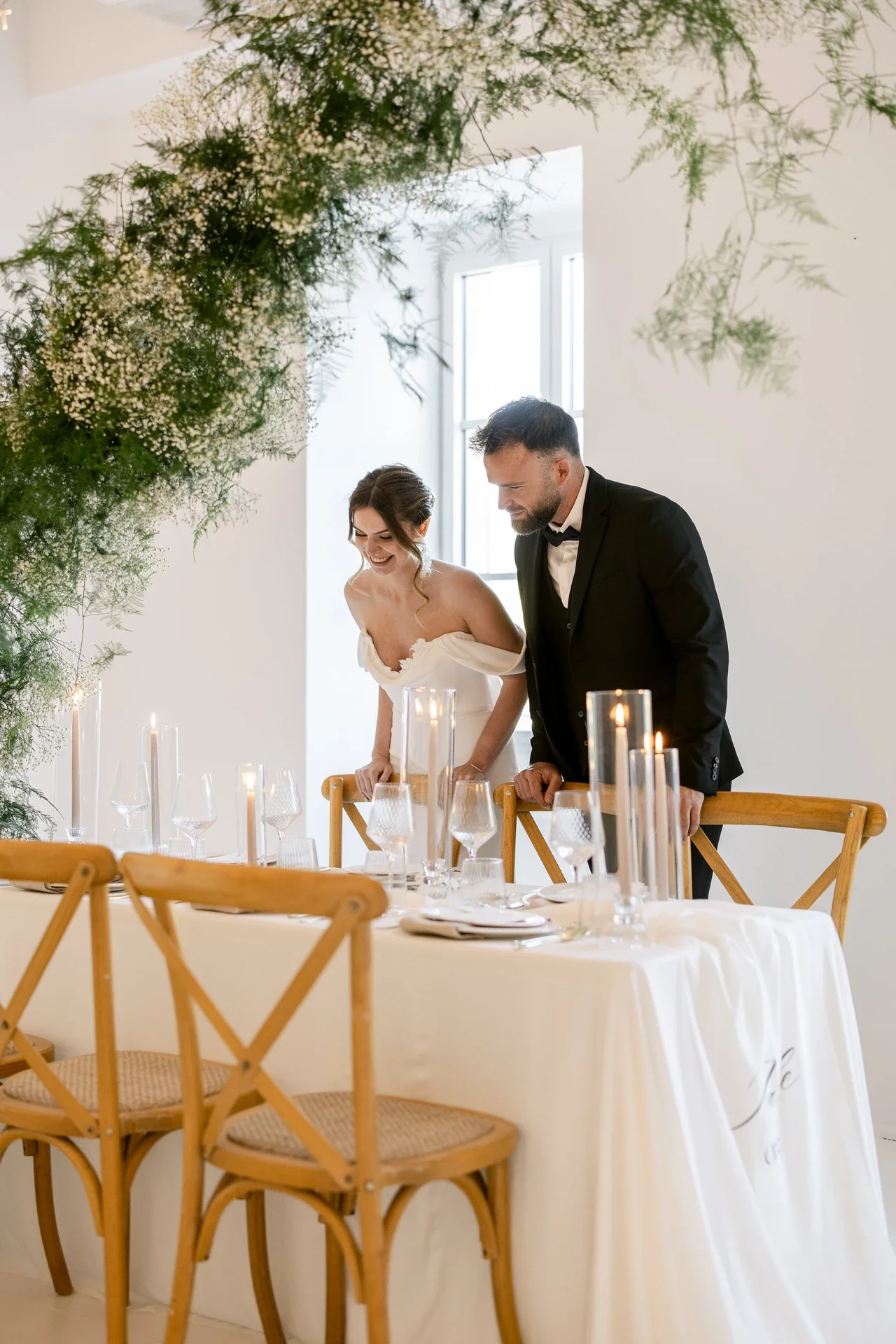 Mariés dressant la table sous une arche de verdure au Château du Griffon