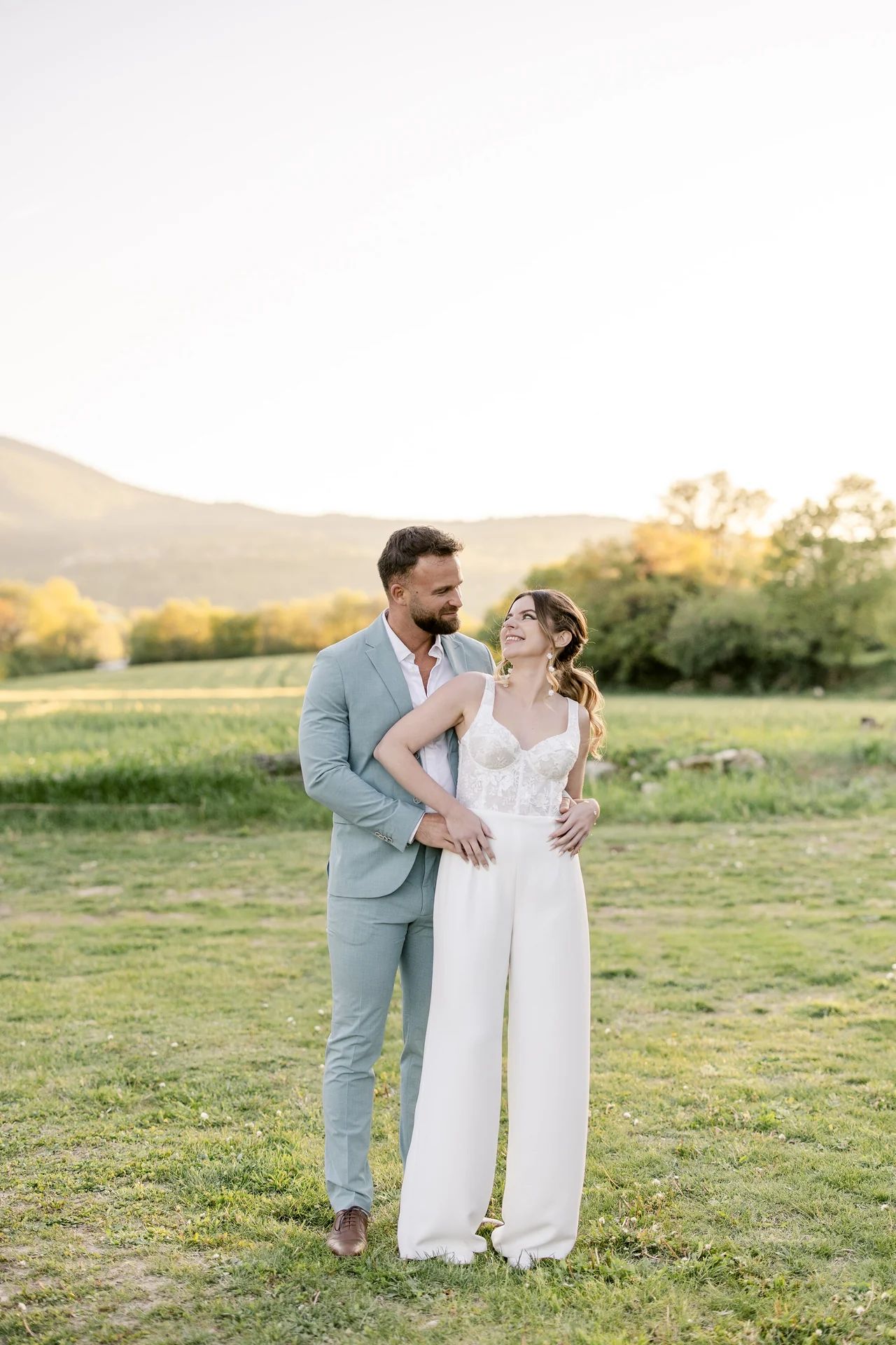 Mariée en combinaison blanche et marié en costume bleu clair dans le Luberon