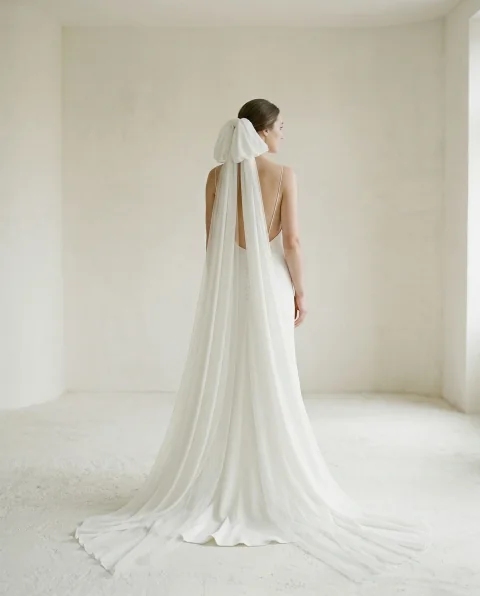 Voile de mariée long en tulle porté sur une robe dos nu, vue de dos